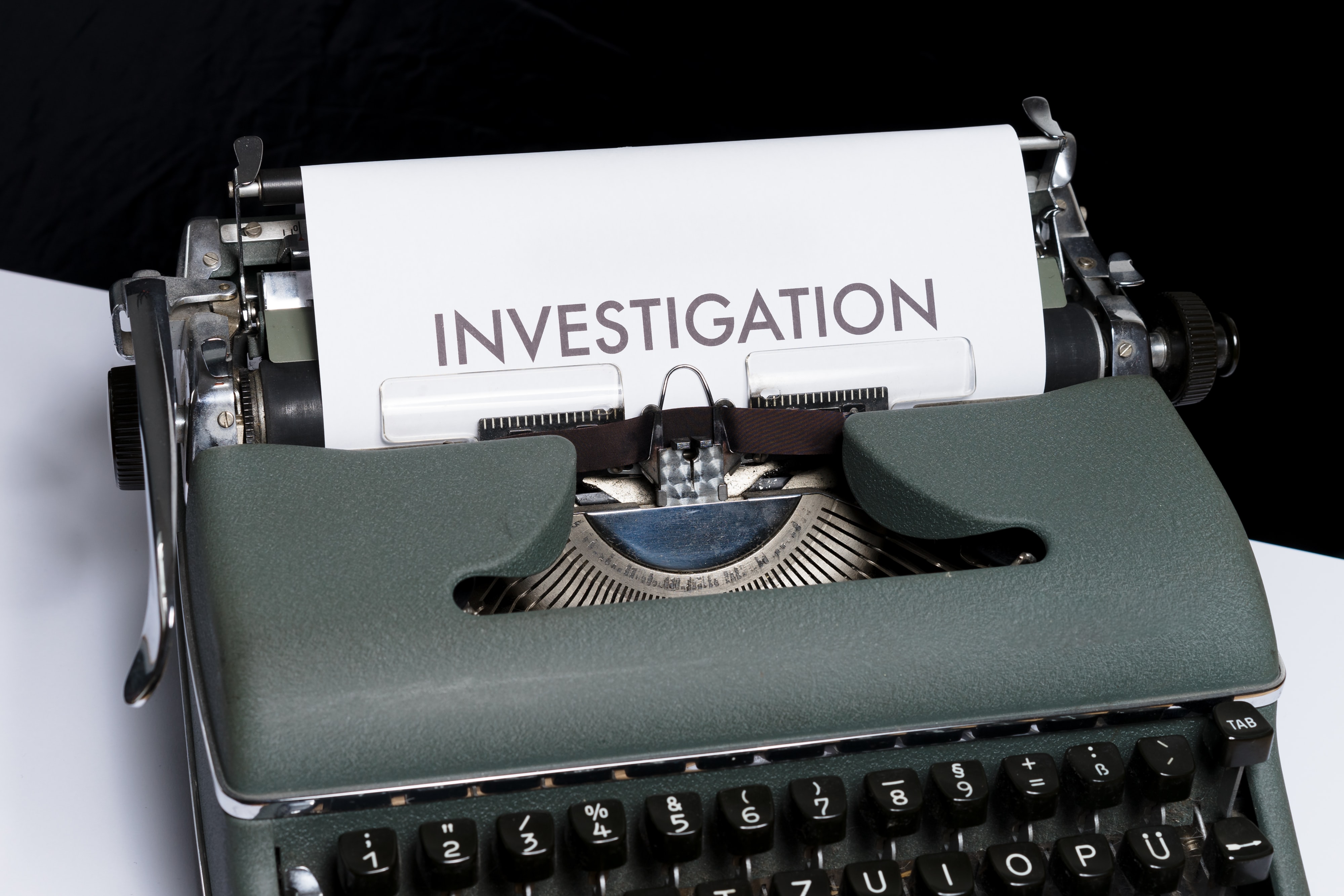 typewriter with word investigation