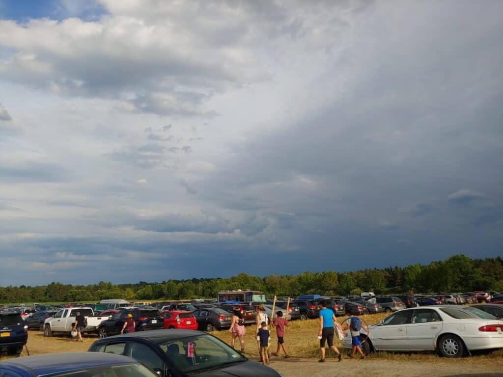 people walking among cars at festival parking lot