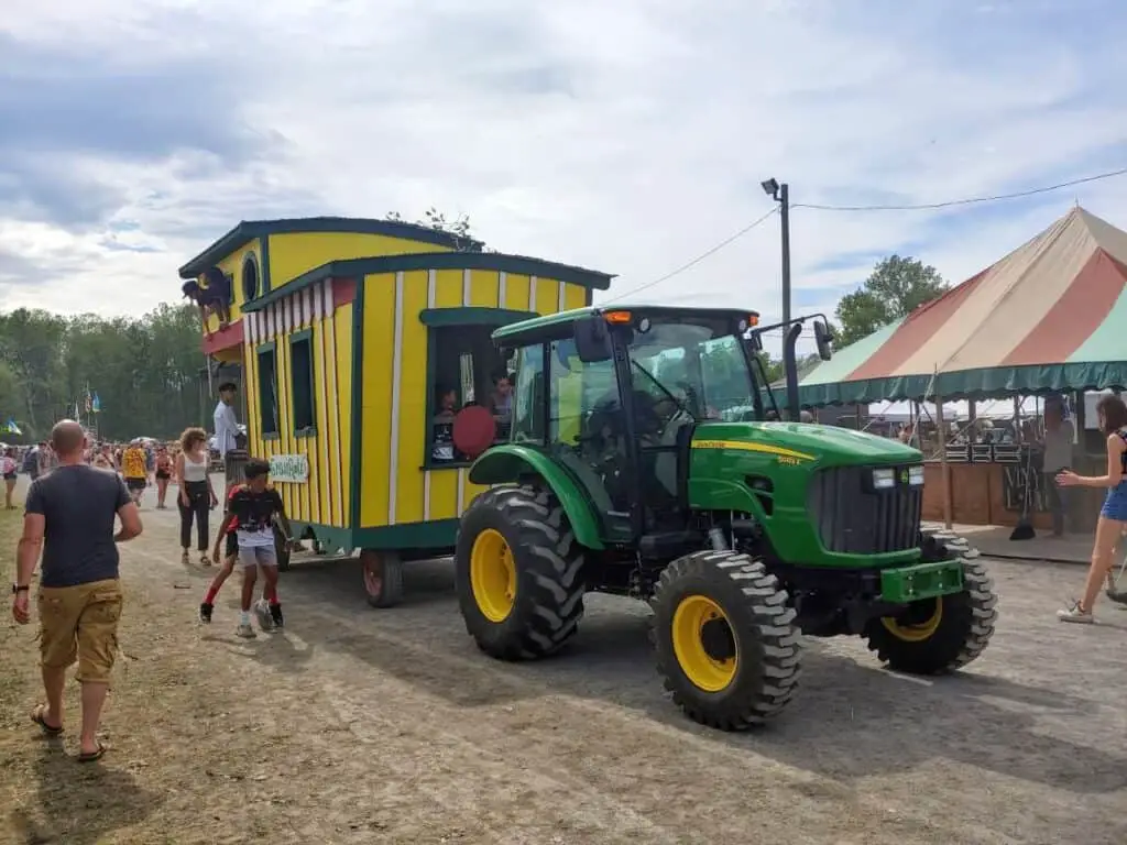 green tractor pulling yellow wagon with people