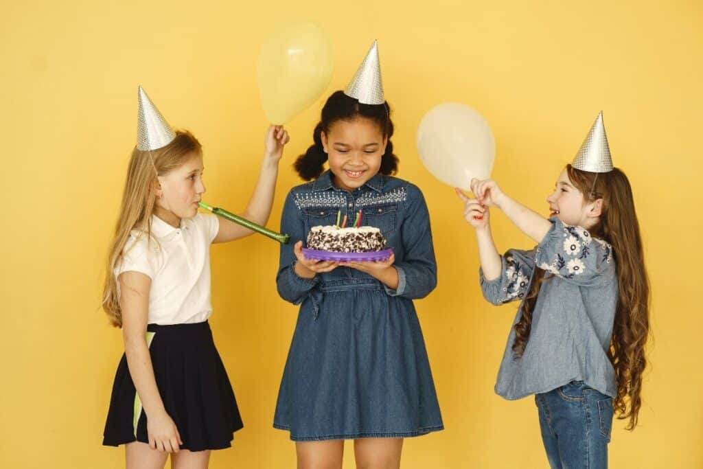 three children in birthday hats